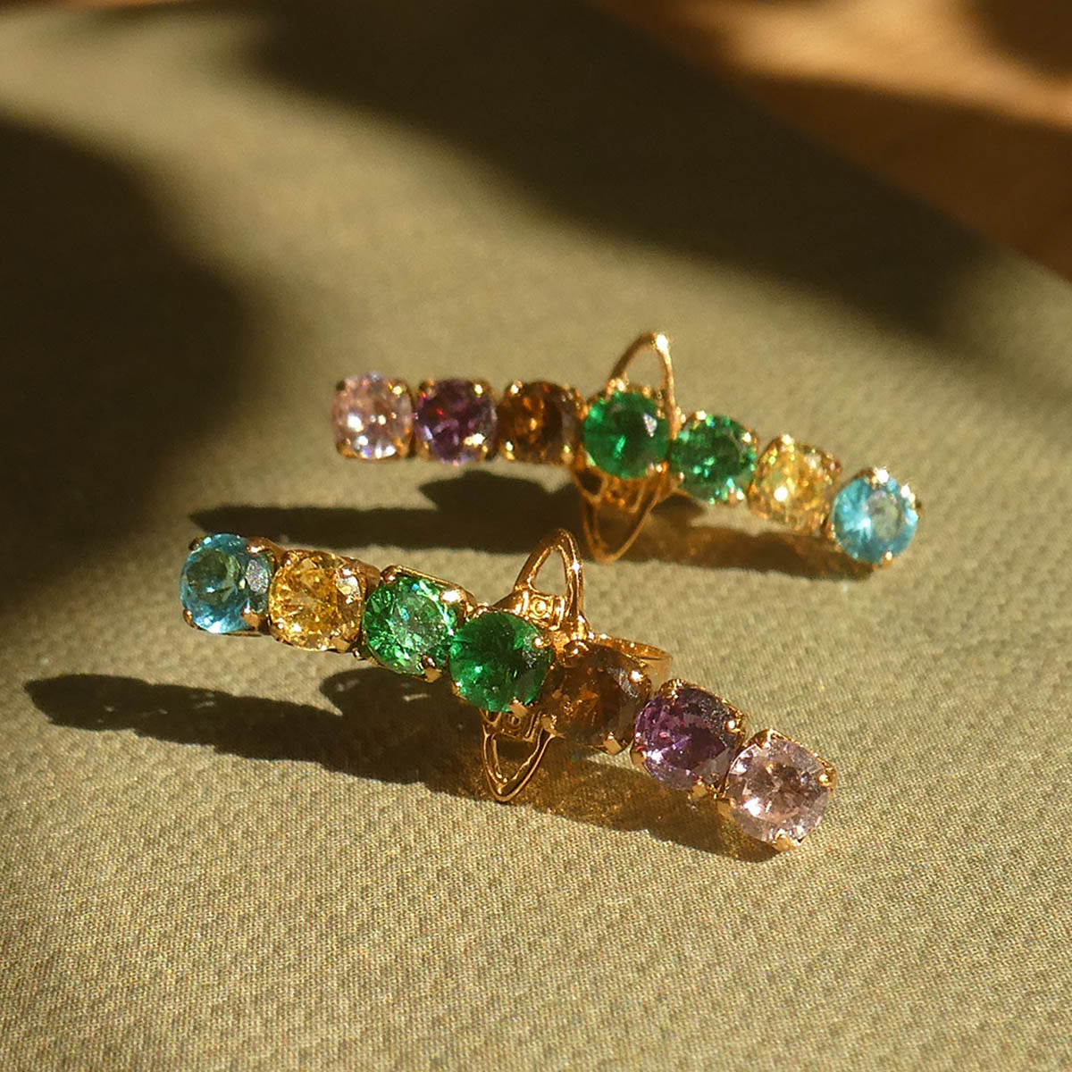 Elegant earrings with colorful gemstones by AN JEWELS JEWELRY Mod. AB.EP035 on display with green fabric background