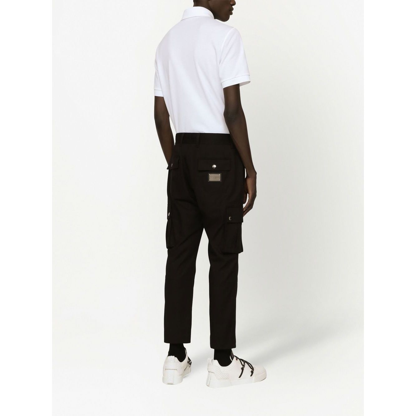 Back view of a person wearing a Dolce & Gabbana Logo cotton polo shirt in white, showcasing the piqué weave and short sleeves.