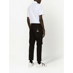Back view of a person wearing a Dolce & Gabbana Logo cotton polo shirt in white, showcasing the piqué weave and short sleeves.