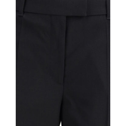 Close-up of Alexander McQueen Black Wool Dress Pants with pleats, straight leg, and refined tailoring details, featuring side and back pockets.