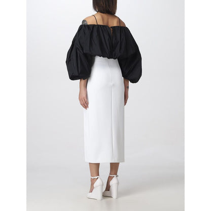 Woman wearing PINKO White Polyester Midi Skirt with thigh slit, back view, size 42, styled with black off-shoulder top and white heels
