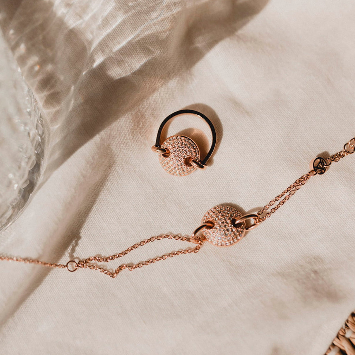 AN JEWELS JEWELRY Mod. AL.BJT01RC rose gold necklace and earrings set displayed on linen fabric.