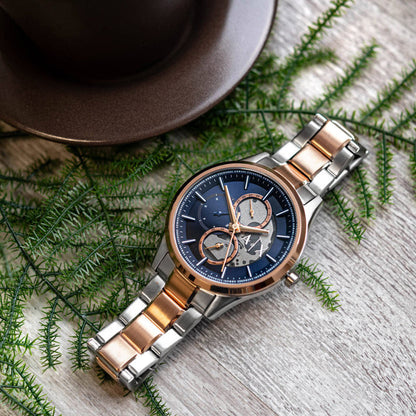ARMANI EXCHANGE Mod. AX1874 wristwatch with SS IP rose gold case, quartz movement, and mineral dial, displayed on a wooden surface with foliage.