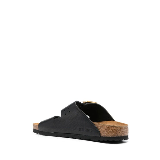Birkenstock Double-strap leather sandals in black leather with gold-tone buckle and logo, featuring flat rubber sole and branded footbed.