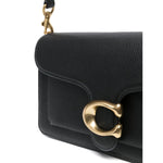 Close-up of Coach Tabby 26 leather shoulder bag with gold hardware, featuring pebbled leather, zip closure, and removable strap.