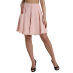 Woman wearing Dolce & Gabbana Light Powder Rose Viscose Pleated Skirt with high waist and elegant flared design.