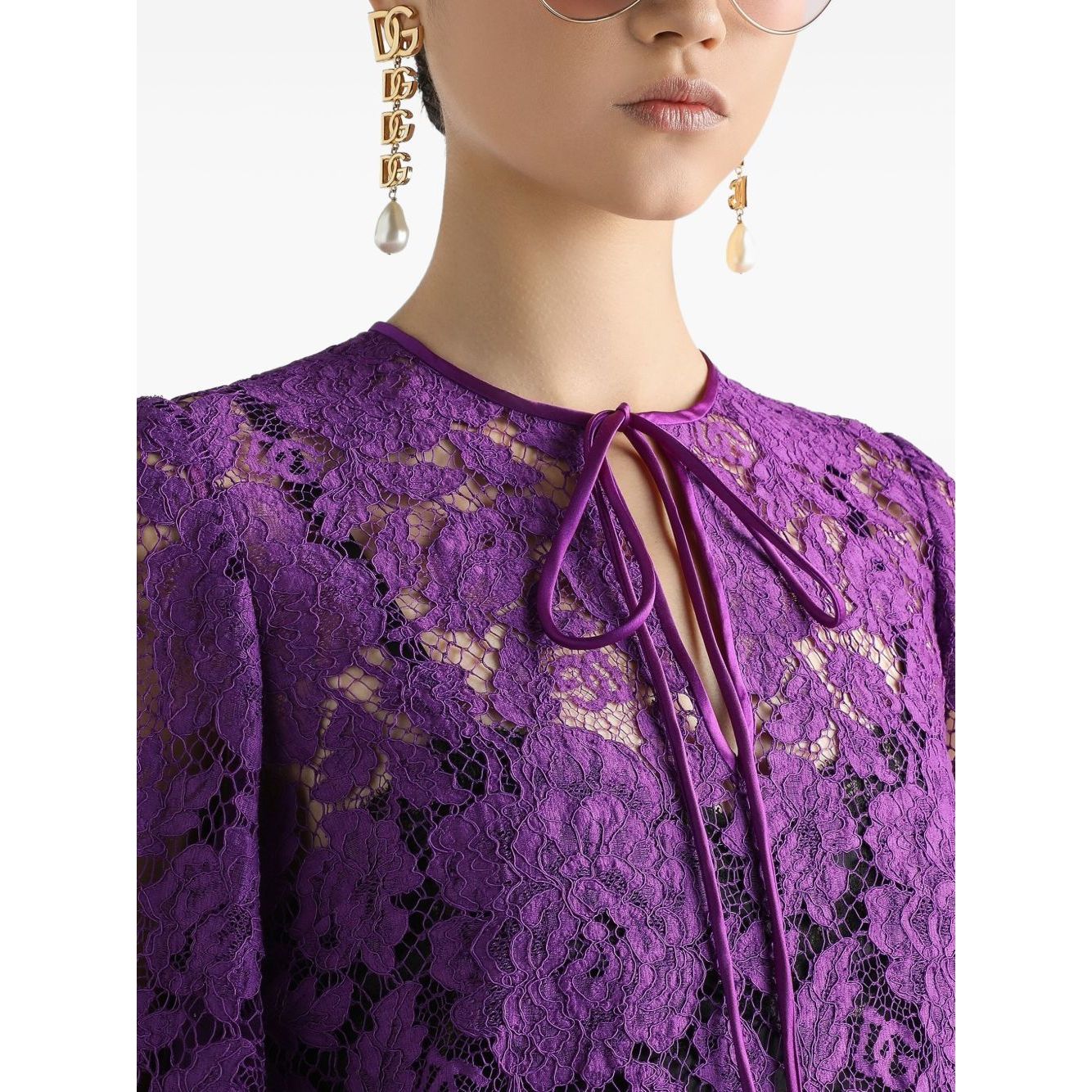 Close-up of Dolce & Gabbana bell sleeves Lace mini dress in amethyst purple with front tie and crew neck details.