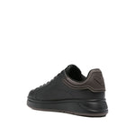 EMPORIO ARMANI EXCLUSIVE Lace-up low-top sneakers in black leather with ribbed panel and flat rubber sole, side view.