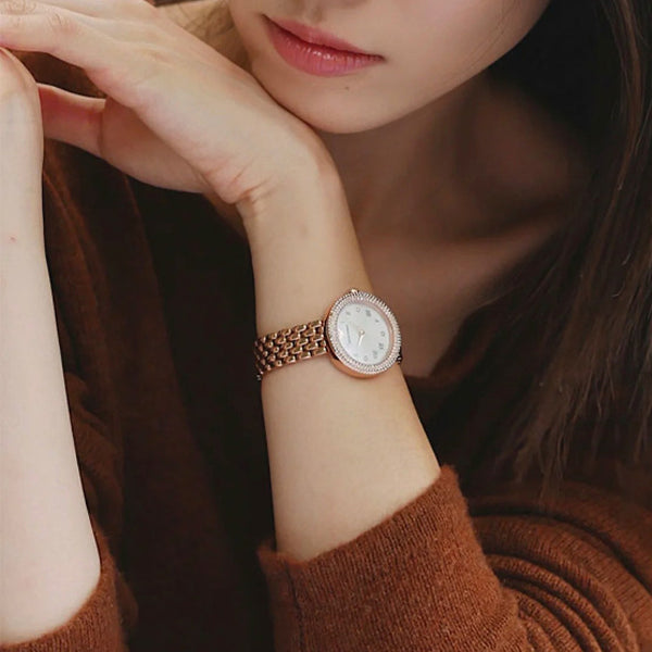 Stylish lady wearing EMPORIO ARMANI MOD. AR11355 wristwatch with rose gold strap, mother of pearl dial, showcasing elegance and luxury.