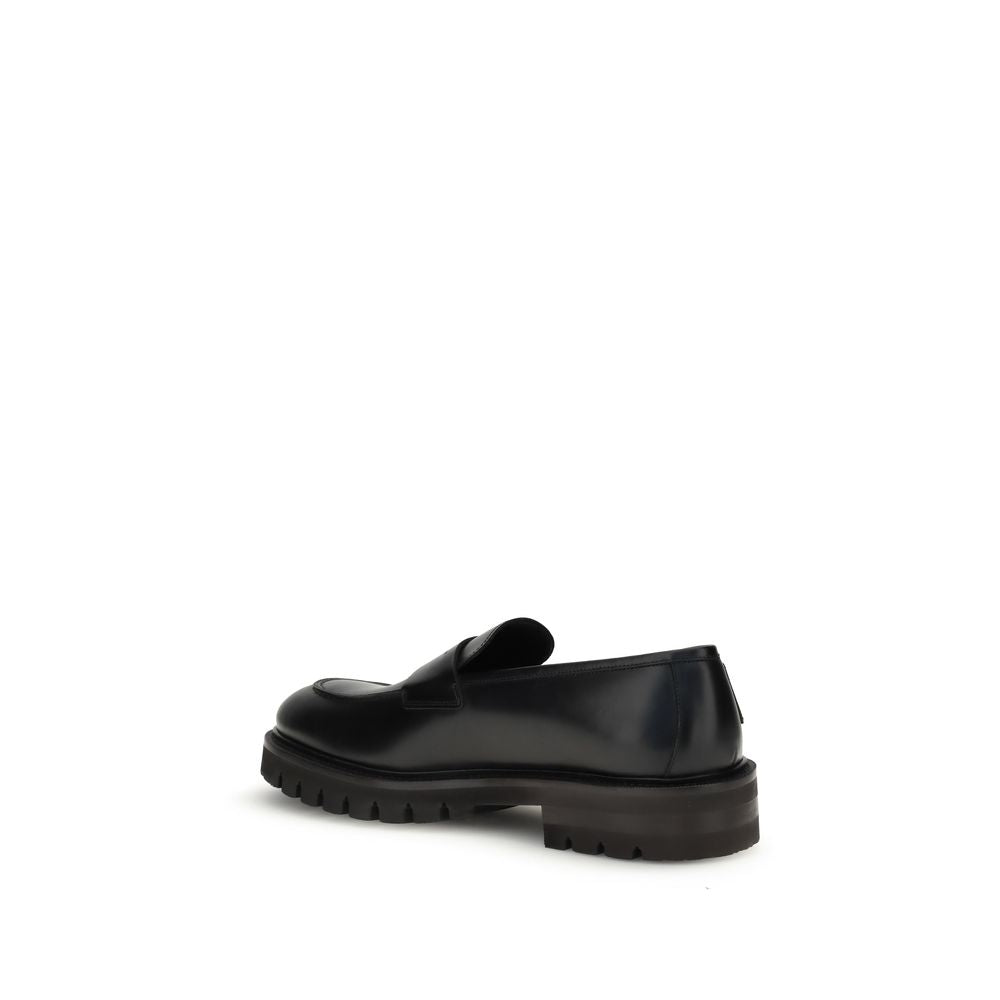 Ferragamo Black Rubber Slip-On Loafers with rugged lug sole and slightly rounded toe, showcasing elegance and modern allure.