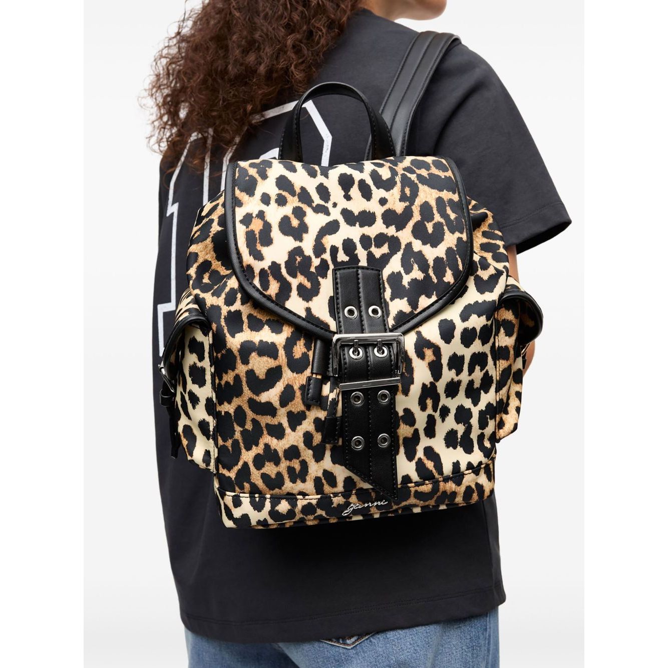 Person carrying Ganni Leopard Small Nylon Bucky Backpack featuring buckle fastening and drawstring closure.