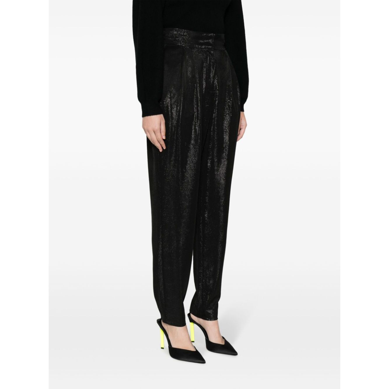 Woman wearing Iro Trousers Black with high waist, straight cut, and high-shine finish, styled with heels, showcasing side pockets detail.