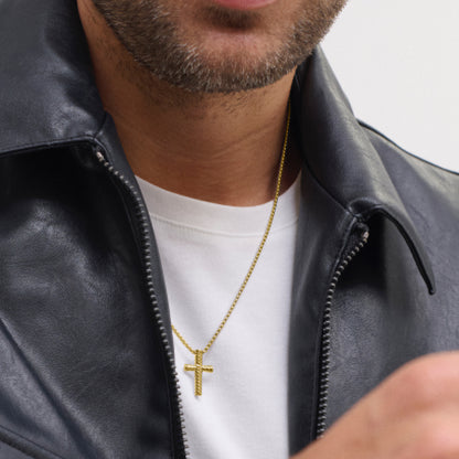 Man wearing black leather jacket and gold cross necklace on white t-shirt