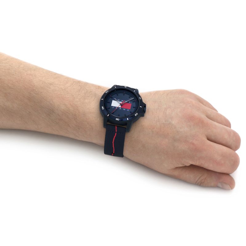 Gent wearing TOMMY HILFIGER Mod. 1791997 quartz analog watch with multifunction 42mm case, 3 ATM water resistance, and mineral dial.