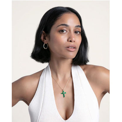 Woman wearing earrings and a green cross necklace, showcasing VICEROY JEWELS Mod. 13190E100-39, elegant and stylish jewelry.