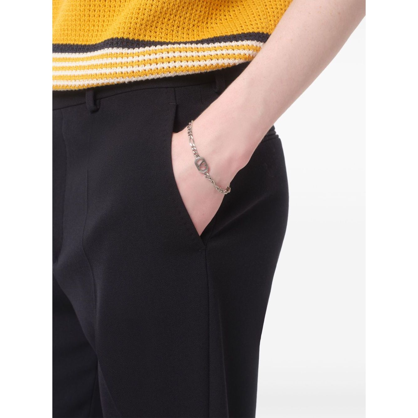 Valentino Garavani Ovalette Bracelet with silver-tone VLogo Signature curb chain on a model's wrist, emphasizing elegance and style.