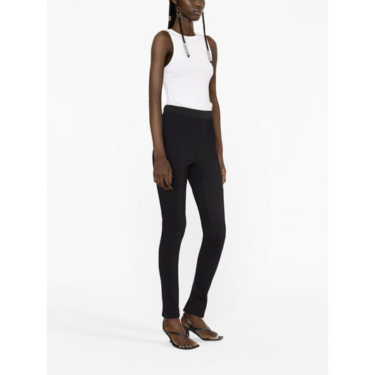Model wearing WARDROBE.NYC Trousers Black, high-waisted stretch leggings with elasticated waistband and rear slit, size S.