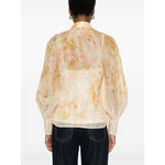 Zimmermann Crush Shirt in light yellow linen-silk blend with floral print, semi-sheer, puff sleeves, and crystal-embellished buttons.
